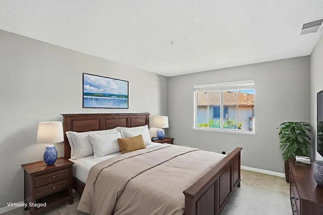 a bedroom with bed and a painting on the wall