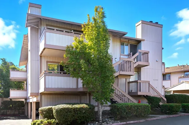 a yellow building with trees in front of it