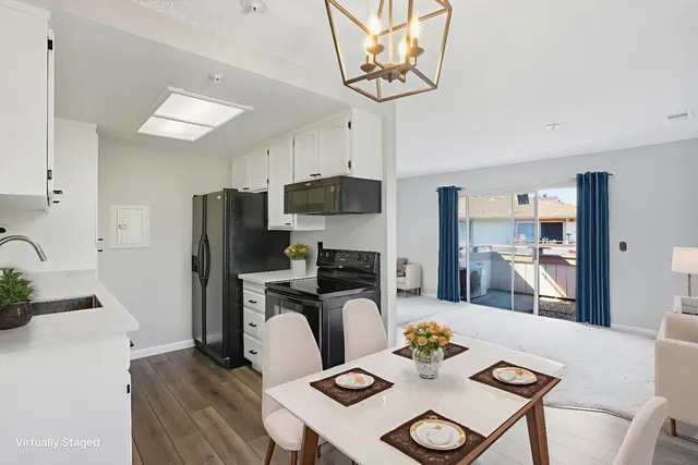 a kitchen with stainless steel appliances granite countertop a sink a stove a refrigerator with a dining table and chairs