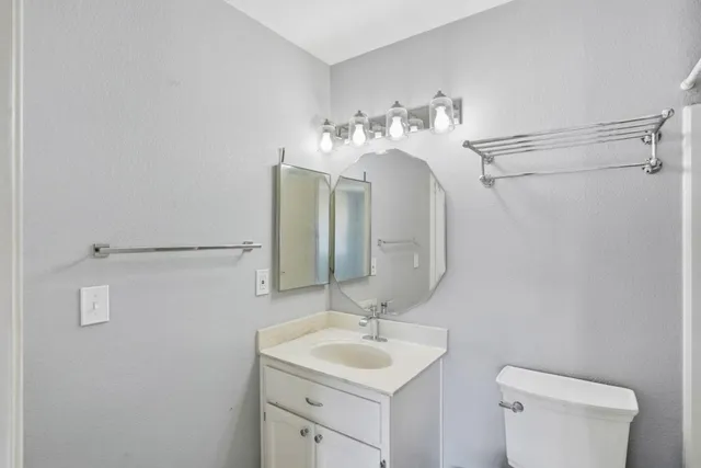 a bathroom with a sink toilet and mirror