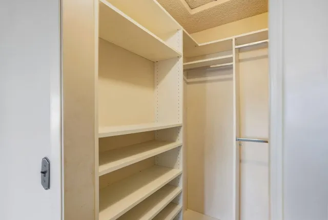 a view of walk in closet with empty racks