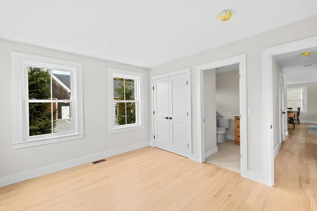a view of an empty room with window and a kitchen