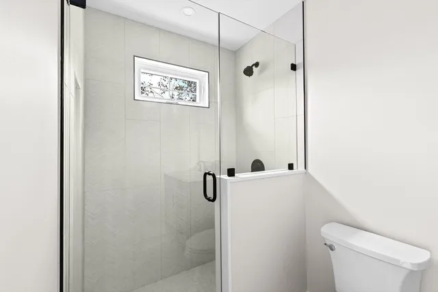 a bathroom with a shower a toilet and a sink