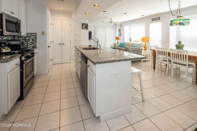 a kitchen with stainless steel appliances kitchen island granite countertop a sink and cabinets