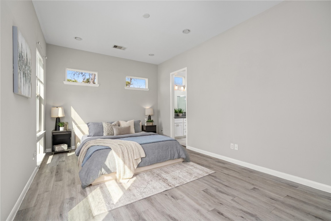 5610 Patrick Street, Unit L Houston, TX 77076 - Photo 17 of 28 a spacious bedroom with a bed and a wooden floor
