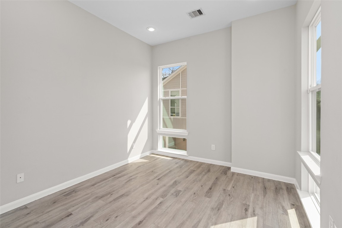 5610 Patrick Street, Unit L Houston, TX 77076 - Photo 21 of 28 a view of an empty room with wooden floor and a window