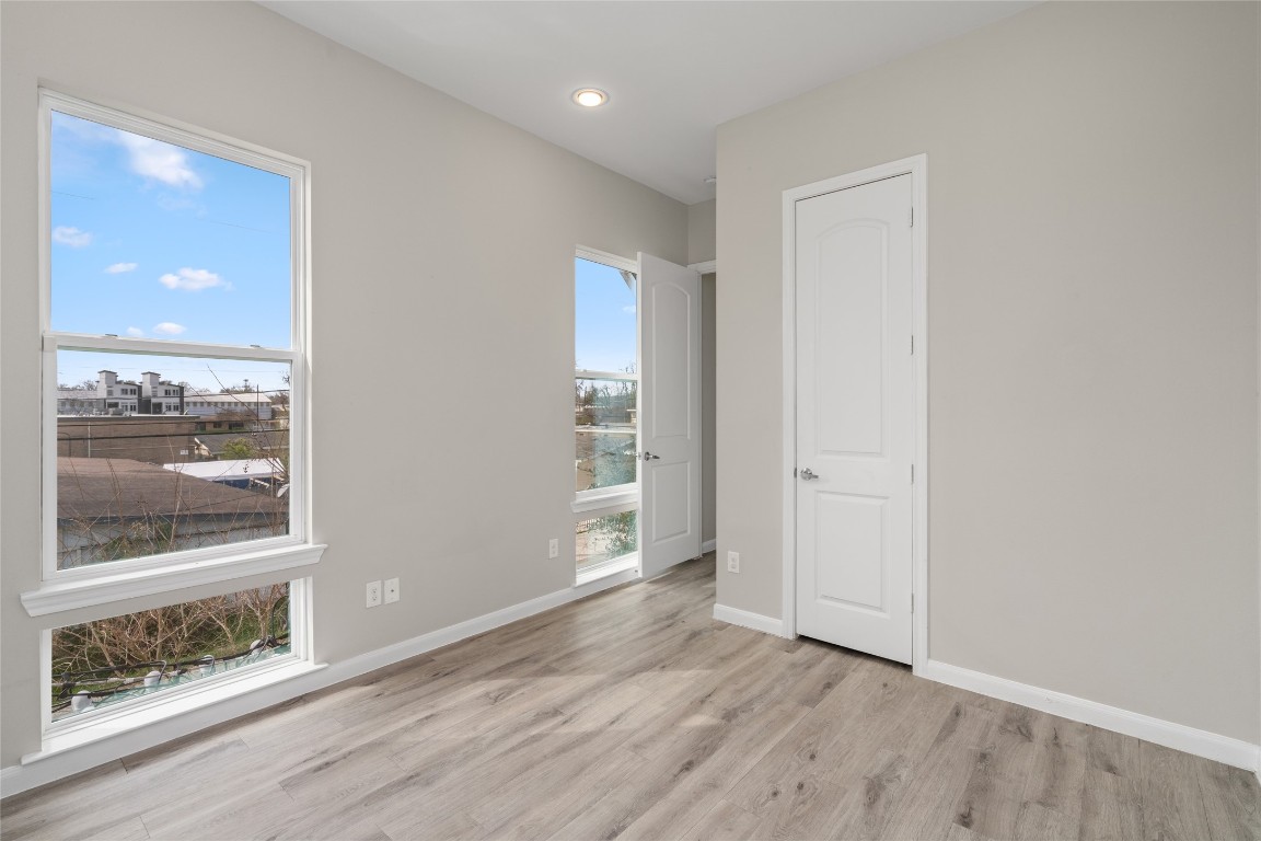 5610 Patrick Street, Unit L Houston, TX 77076 - Photo 22 of 28 an empty room with wooden floor and windows