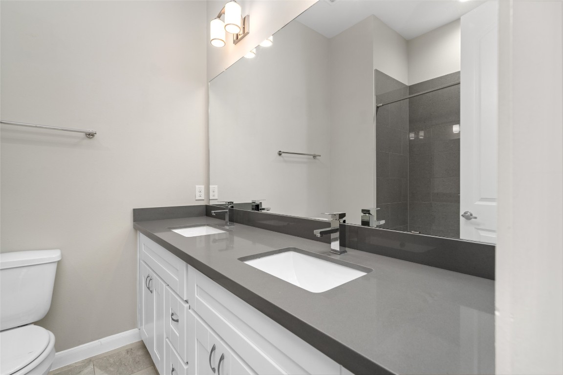 5610 Patrick Street, Unit L Houston, TX 77076 - Photo 23 of 28 a bathroom with a granite countertop sink a toilet and a mirror
