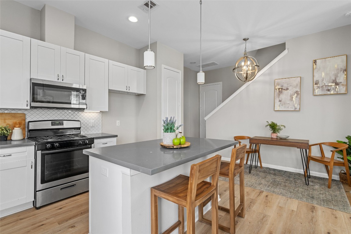 5610 Patrick Street, Unit L Houston, TX 77076 - Photo 3 of 28 a kitchen with stainless steel appliances granite countertop a stove a kitchen island a dining table and chairs
