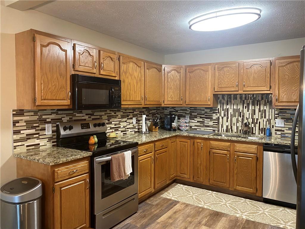 725 Rollinson Road Hermitage, PA 16148 - Photo 7 of 26 a kitchen with stainless steel appliances granite countertop a stove microwave and sink