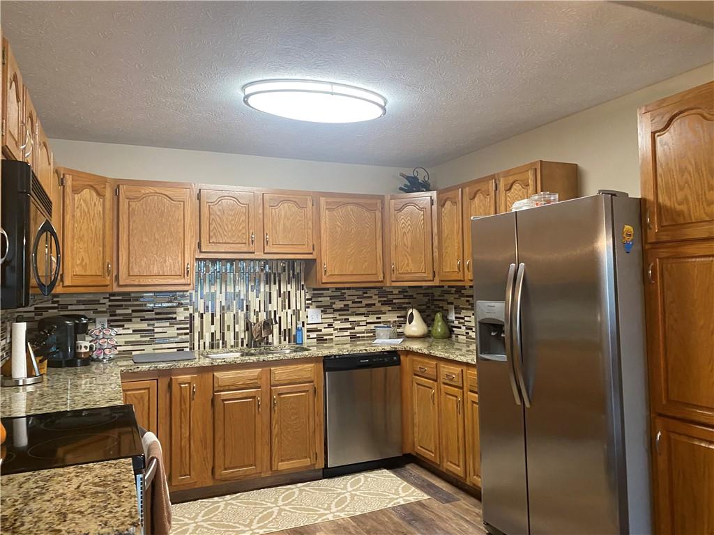 725 Rollinson Road Hermitage, PA 16148 - Photo 8 of 26 a kitchen with stainless steel appliances granite countertop a refrigerator sink and cabinets