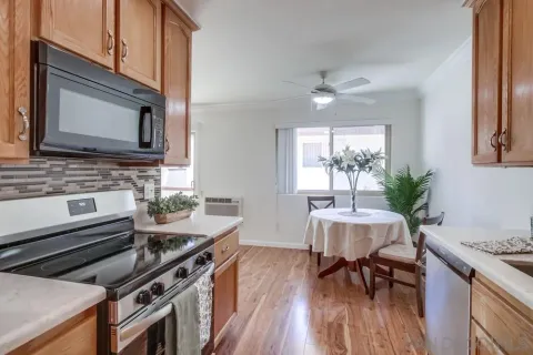 a kitchen with a stove a sink and wooden floor