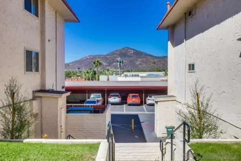 a view of pool with lawn chairs and plants