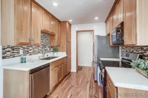a kitchen with kitchen island granite countertop a sink stove and refrigerator