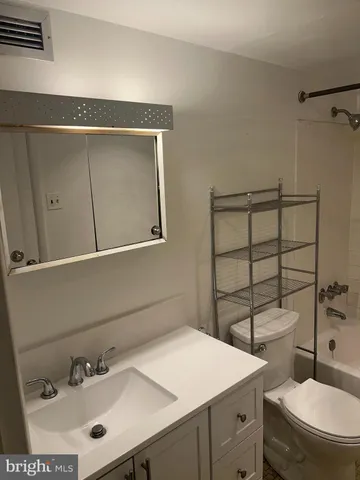 a bathroom with a sink a toilet and mirror