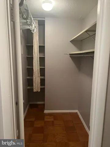 a view of walk in closet with empty racks