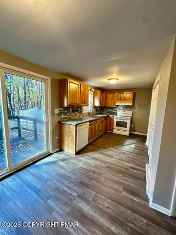a view of a kitchen with wooden floor and electronic appliances