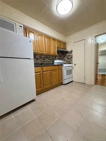 a kitchen with a refrigerator a stove top oven and cabinets