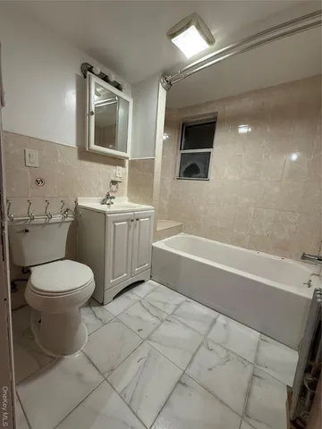 a bathroom with a toilet a sink a mirror and bathtub