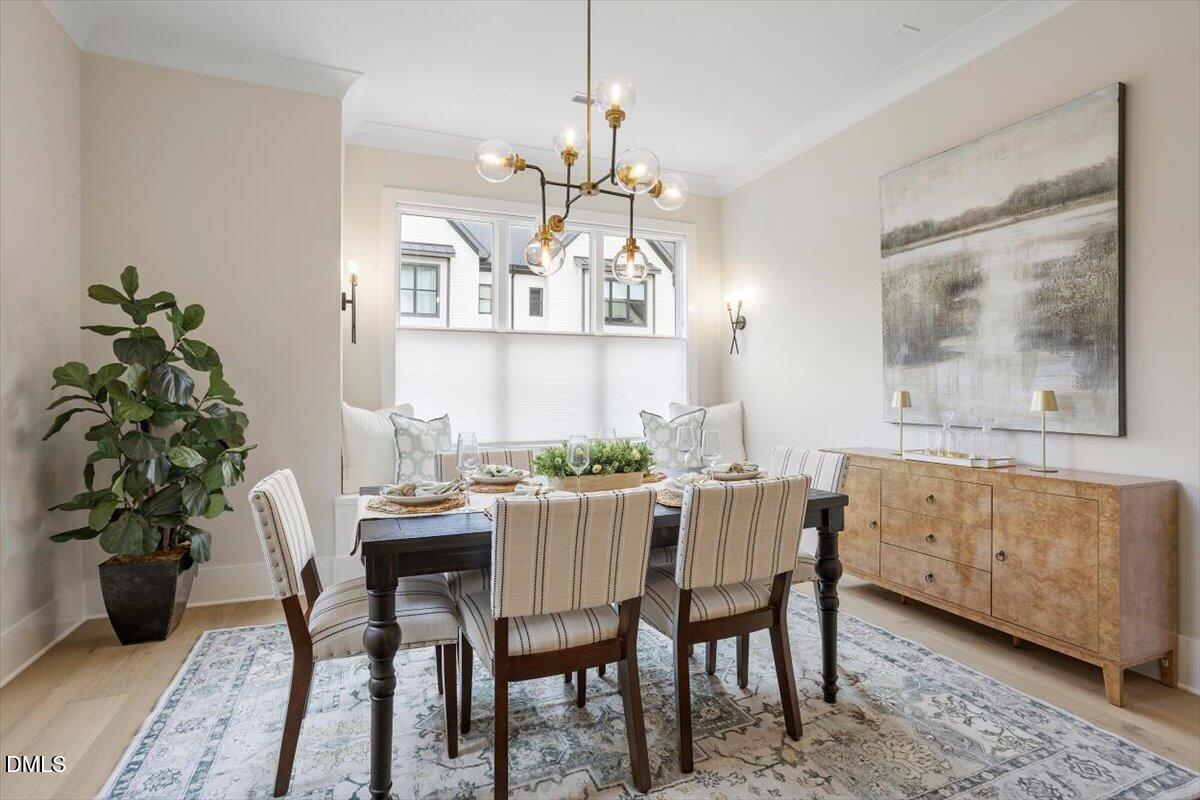 811 Maple Berry Lane, Unit 101 Raleigh, NC 27607 - Photo 13 of 45 a dining room with furniture potted plants and wooden floor