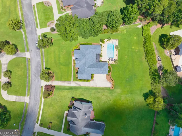 an aerial view of a house with table and chairs under an umbrella