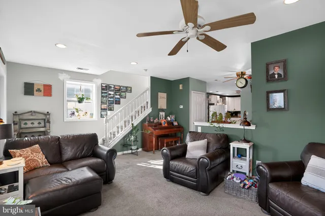 a living room with furniture and a ceiling fan