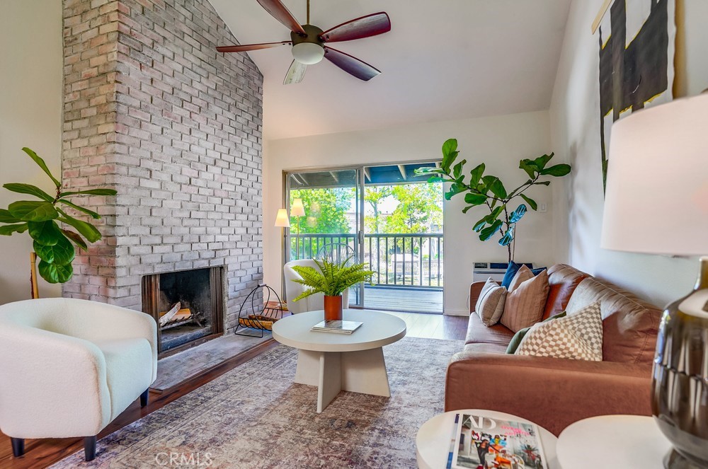 7890 East Spring Street, Unit 26E Long Beach, CA 90815 - Photo 1 of 1 a living room with furniture and a fireplace