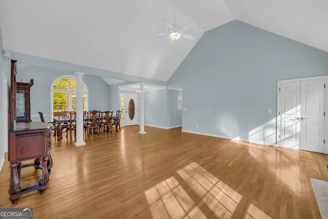 a view of an empty room with wooden floor and windows