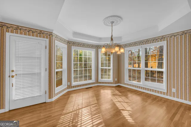 a dining room with furniture a chandelier and wooden floor