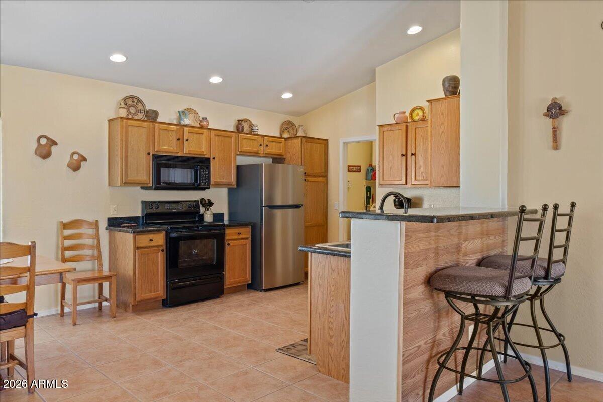 14234 South Capistrano Road Arizona City, AZ 85123 - Photo 12 of 42 a kitchen with stainless steel appliances a refrigerator and a stove top oven