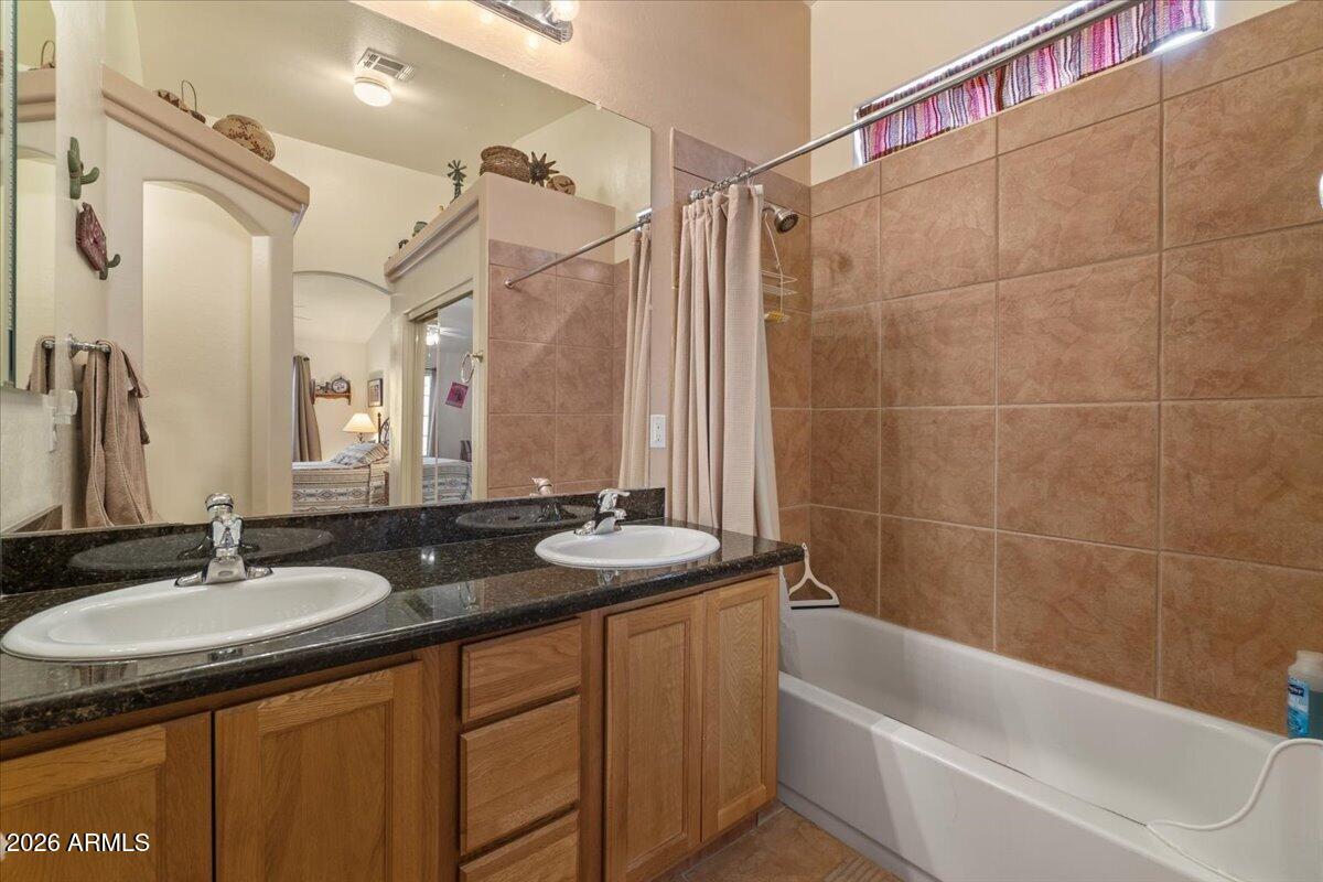 14234 South Capistrano Road Arizona City, AZ 85123 - Photo 22 of 42 a bathroom with a granite countertop sink a mirror a bathtub and shower