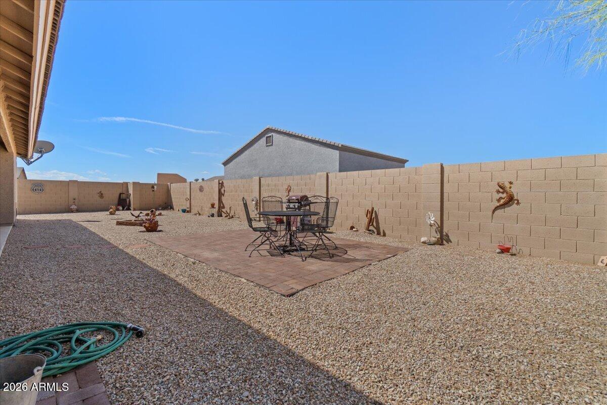14234 South Capistrano Road Arizona City, AZ 85123 - Photo 33 of 42 a view of a backyard with table and chairs under an umbrella