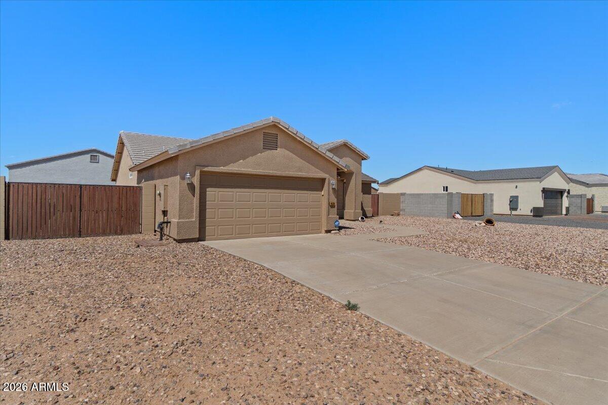 14234 South Capistrano Road Arizona City, AZ 85123 - Photo 39 of 42 a front view of a house with a yard and garage