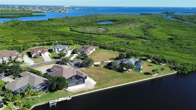 an aerial view of a house with a garden and lake view