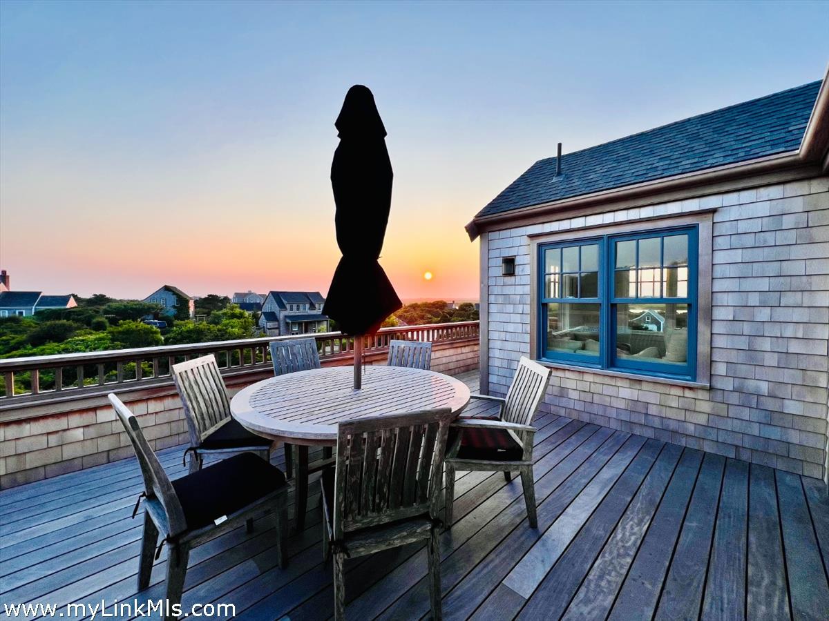 3 Tautemo Way Nantucket, MA 02554 - Photo 21 of 57 a view of deck with table and chairs couches with wooden floor