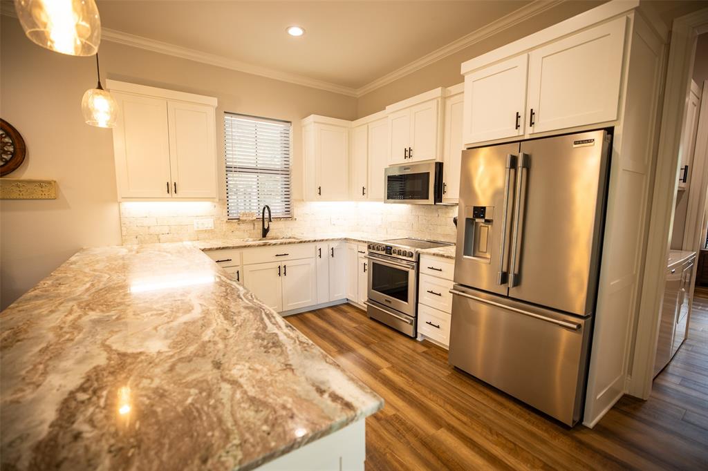 450 Northeast Loop 7 Athens, TX 75751 - Photo 22 of 38 a kitchen with granite countertop a refrigerator sink and microwave