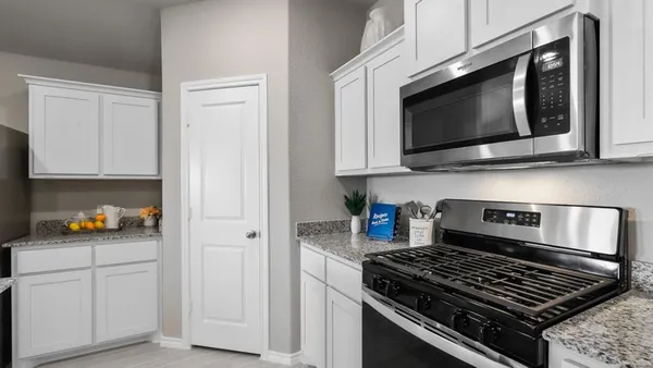a kitchen with stainless steel appliances granite countertop white cabinets and black stove top oven with granite countertops