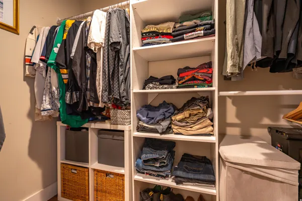 a view of walk in closet with clothes and shoes