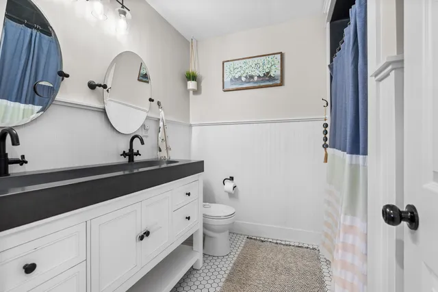 a bathroom with a granite countertop sink a toilet and a mirror