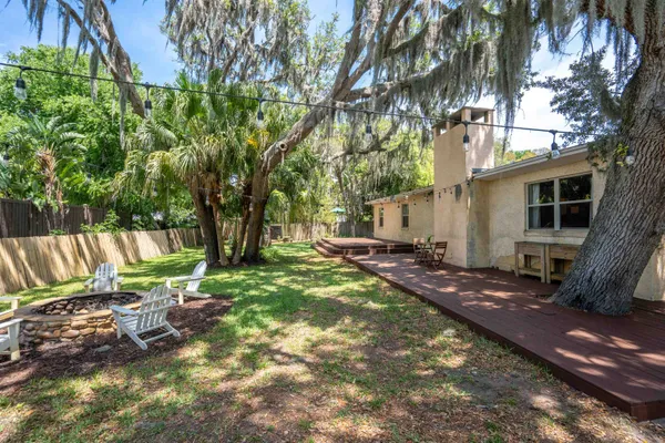 a view of backyard with deck and outdoor seating