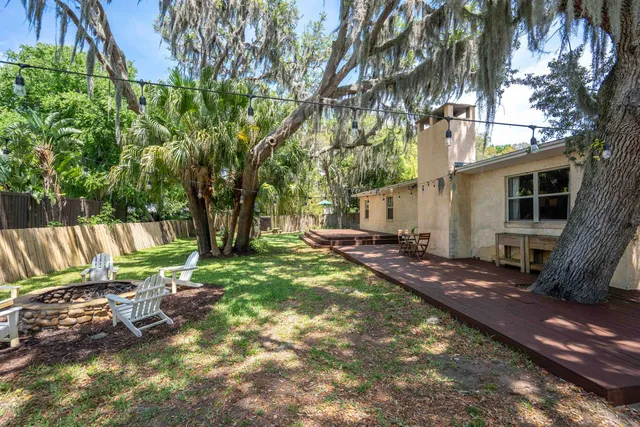 a view of backyard with deck and outdoor seating