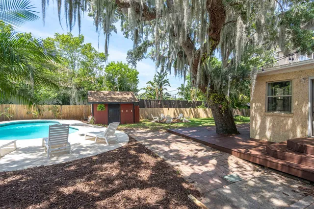 a view of a yard with plants and trees
