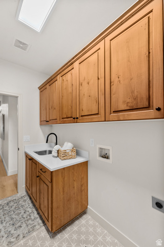 340 Brayden Way Draper, UT 84020 - Photo 32 of 58 Warm-toned wood cabinetry, built-in sink with a black faucet, white countertop, and patterned floor tile