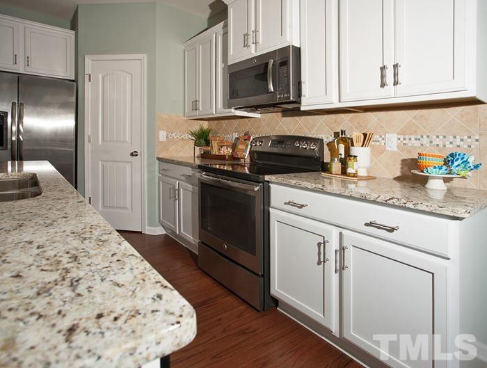 3003 Bluegrove Road Raleigh, NC 27610 - Photo 7 of 25 a kitchen with stainless steel appliances granite countertop a stove a sink and a microwave