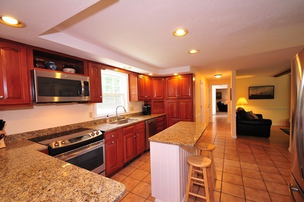 29 Johnson Road Sutton, MA 01590 - Photo 7 of 29 a kitchen with stainless steel appliances granite countertop a stove top oven a sink dishwasher a dining table and chairs with wooden floor