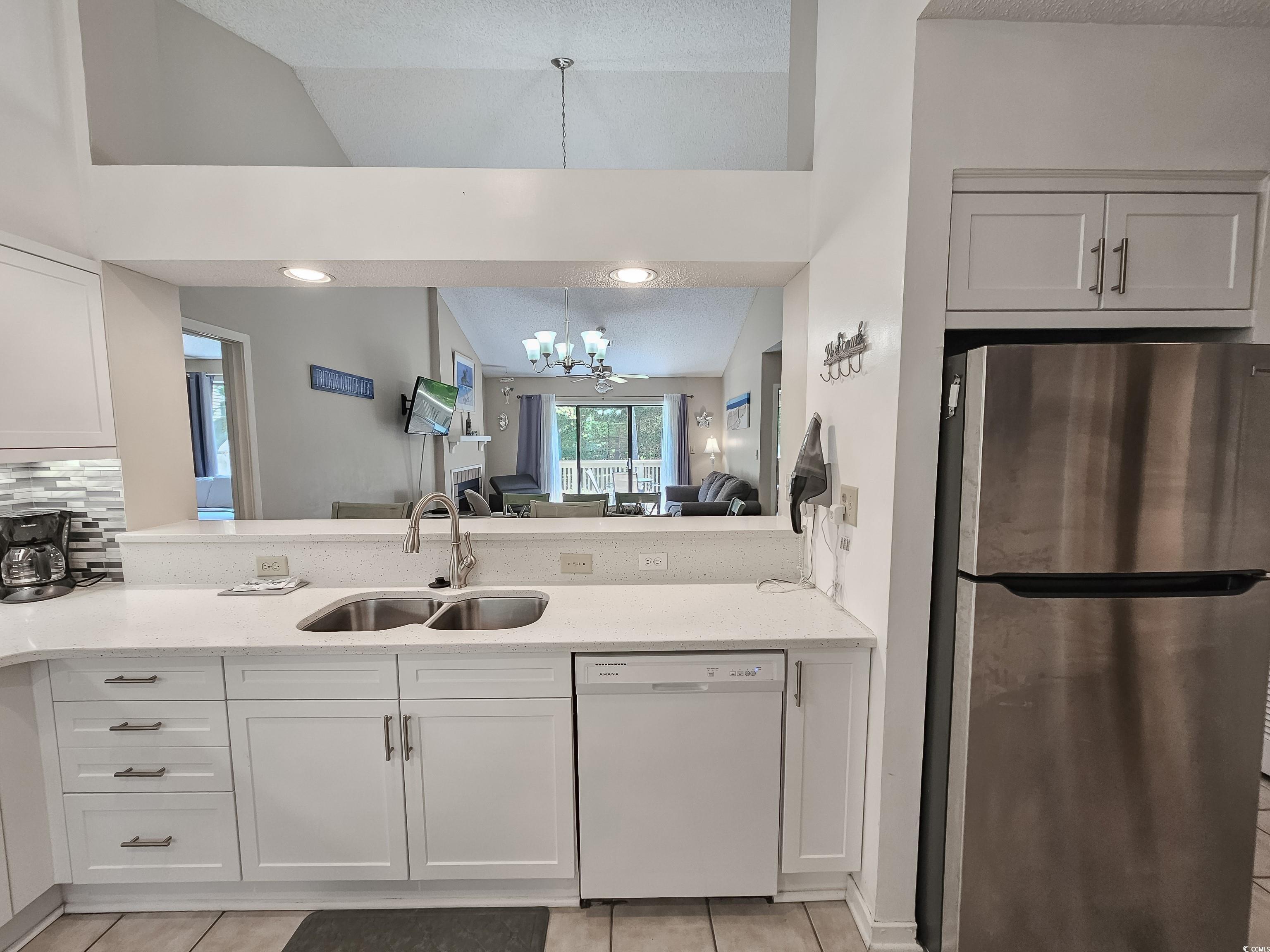 210 Westleton Drive, Unit 13D Myrtle Beach, SC 29572 - Photo 15 of 40 Kitchen with freestanding refrigerator, dishwasher, a sink, a chandelier, and light tile patterned floors