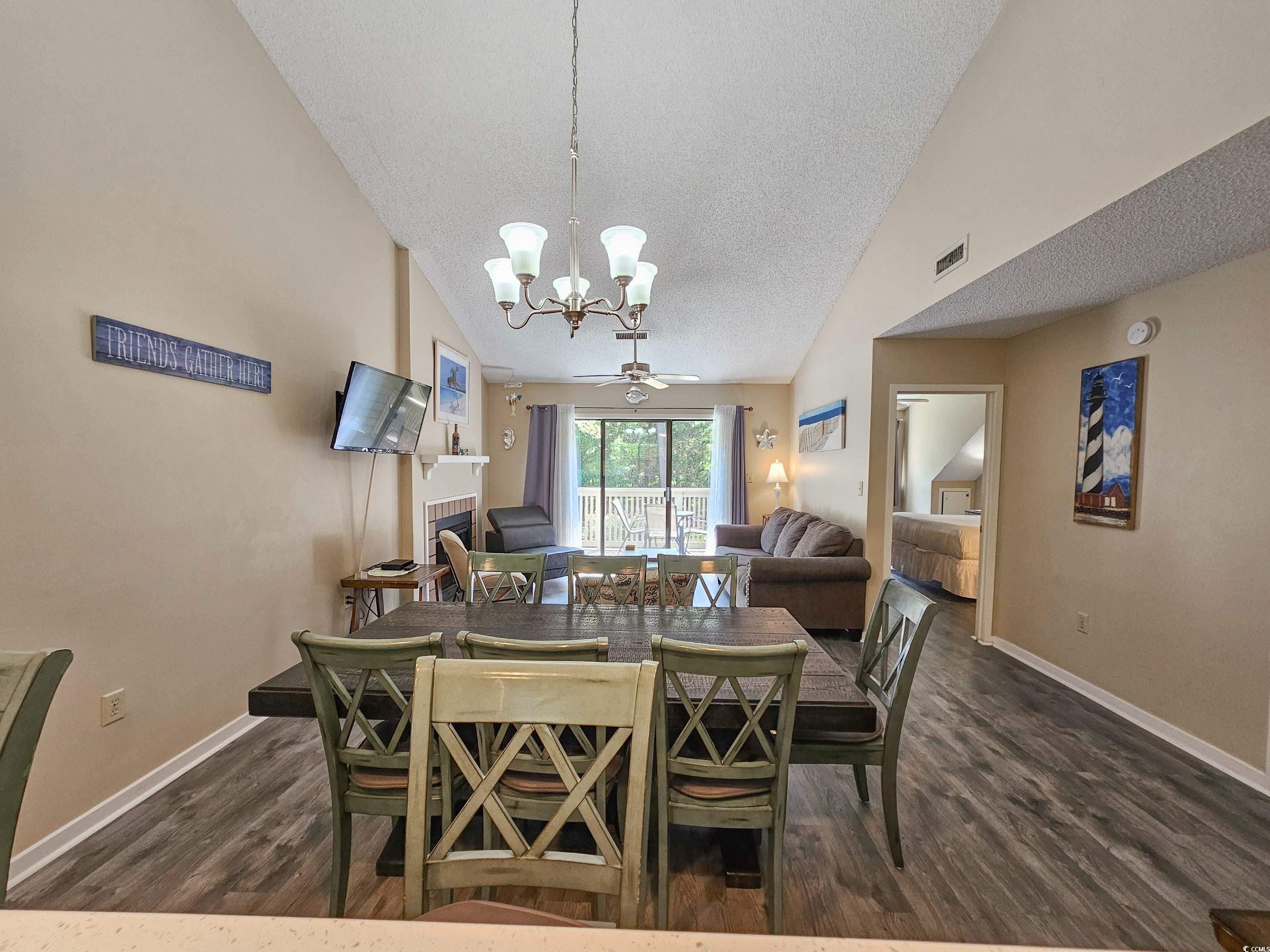 210 Westleton Drive, Unit 13D Myrtle Beach, SC 29572 - Photo 16 of 40 Dining space with a chandelier, dark wood-style floors, a textured ceiling, baseboards, and vaulted ceiling
