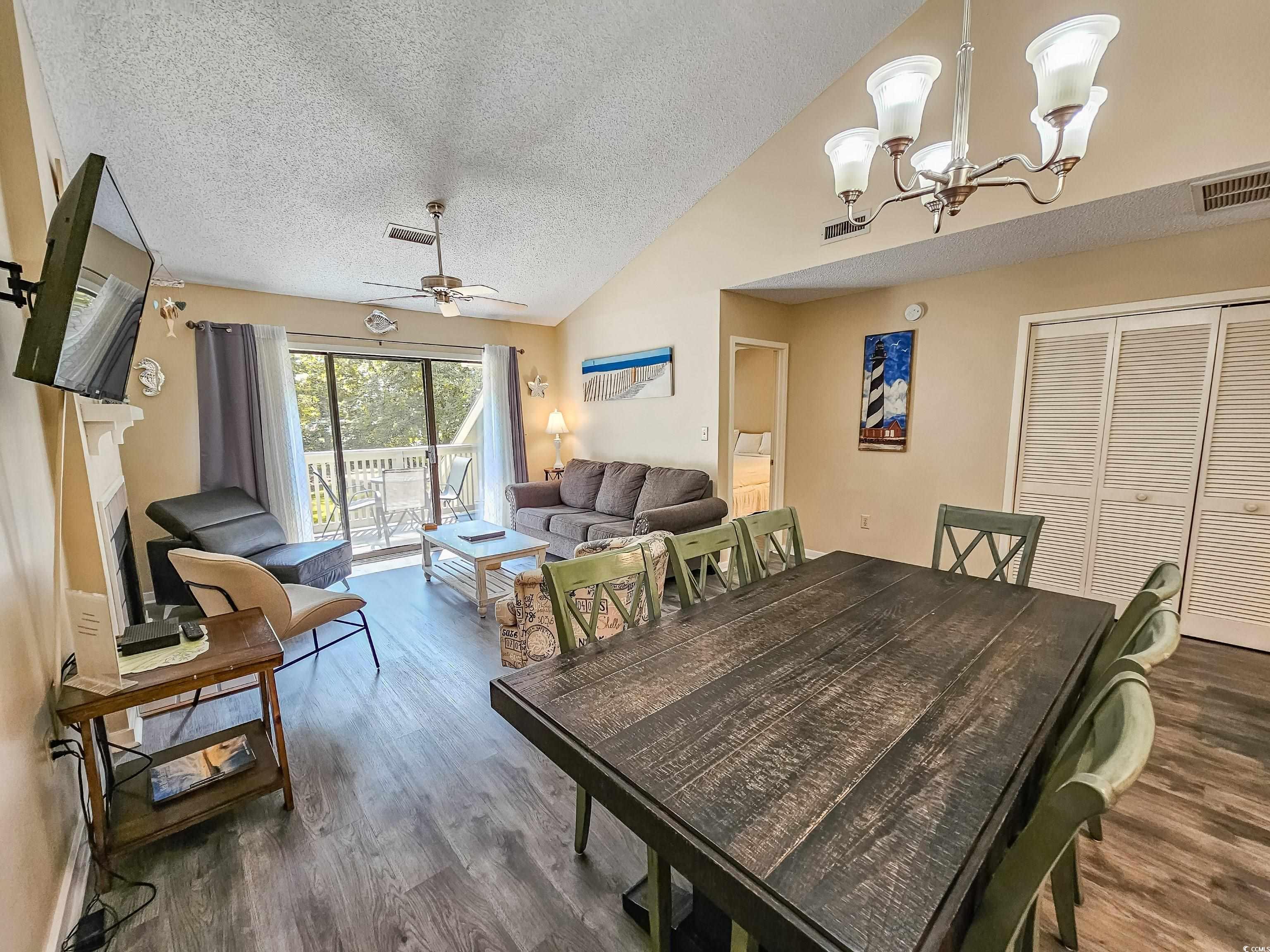 210 Westleton Drive, Unit 13D Myrtle Beach, SC 29572 - Photo 19 of 40 Dining space featuring wood finished floors, a textured ceiling, lofted ceiling, a chandelier, and ceiling fan