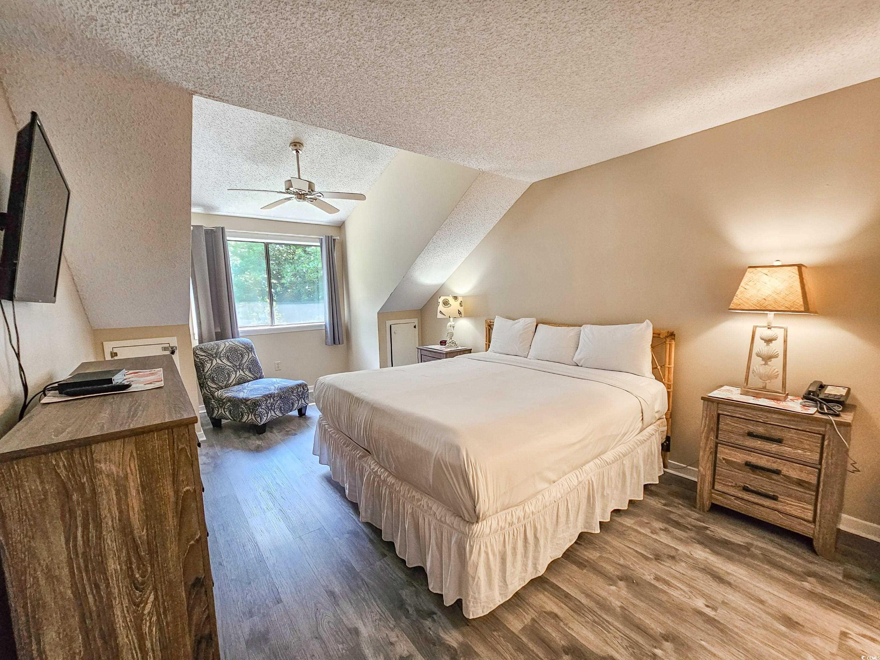 210 Westleton Drive, Unit 13D Myrtle Beach, SC 29572 - Photo 20 of 40 Bedroom featuring a textured ceiling, dark wood finished floors, a ceiling fan, and baseboards