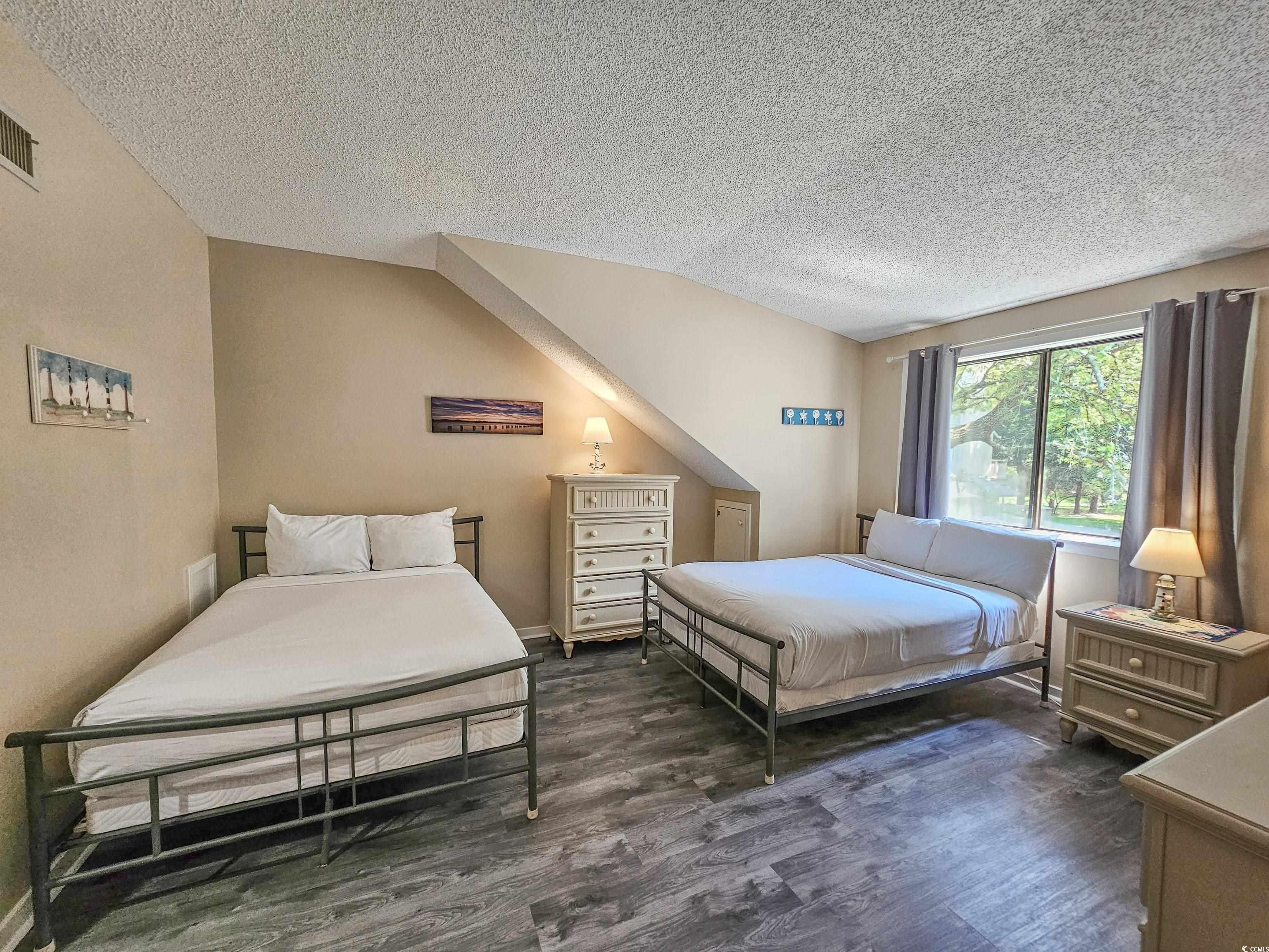210 Westleton Drive, Unit 13D Myrtle Beach, SC 29572 - Photo 26 of 40 Bedroom with a textured ceiling, wood finished floors, and vaulted ceiling